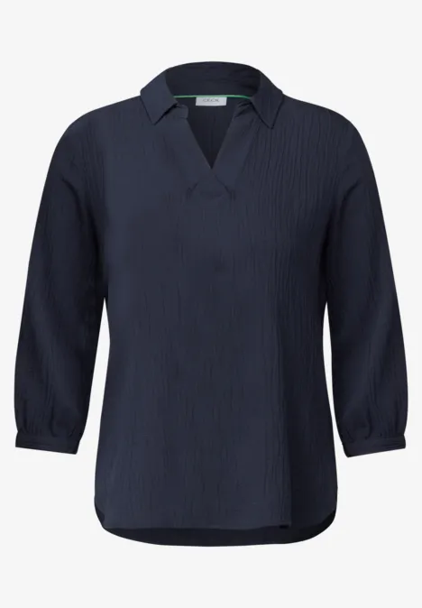 Dunkelblaue Bluse mit V-Ausschnitt und langen Ärmeln.